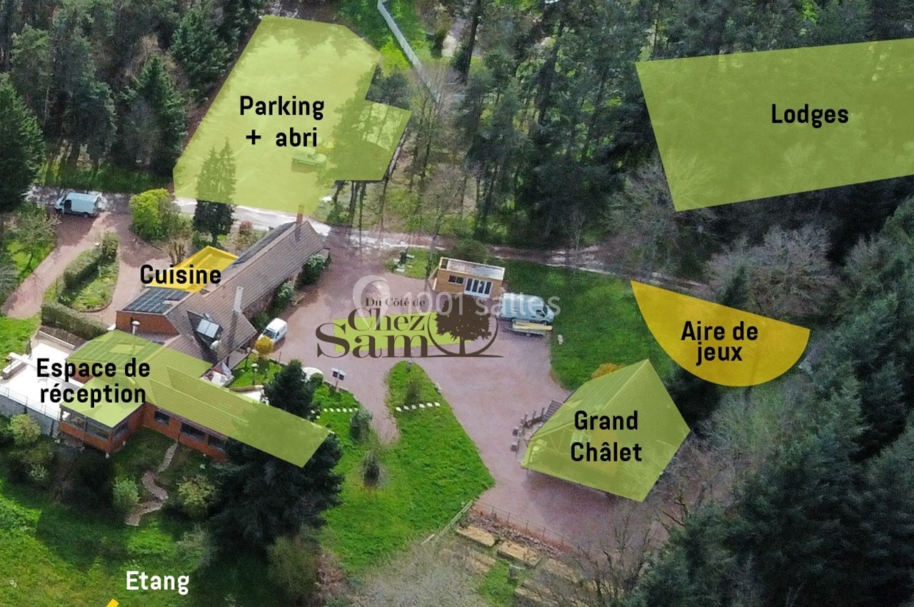Vue aérienne d'un domaine forestier avec chalets, aire de jeux, étang, parking et espaces de réception.