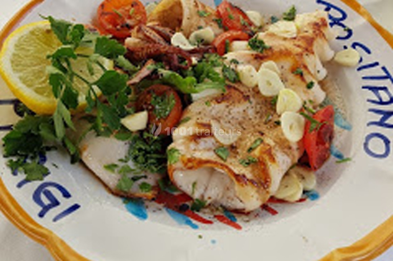 Assiette de calamars grillés garnis de tomates, ail, persil et citron, servie sur une assiette décorative.