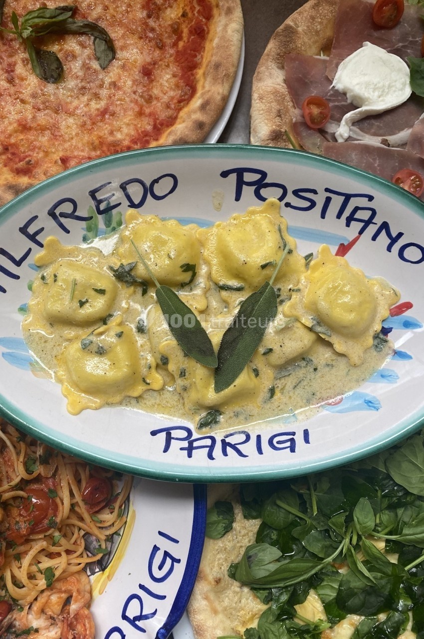 Assiette de raviolis sauce crémeuse au beurre et sauge, entourée de pizzas et de plats italiens.