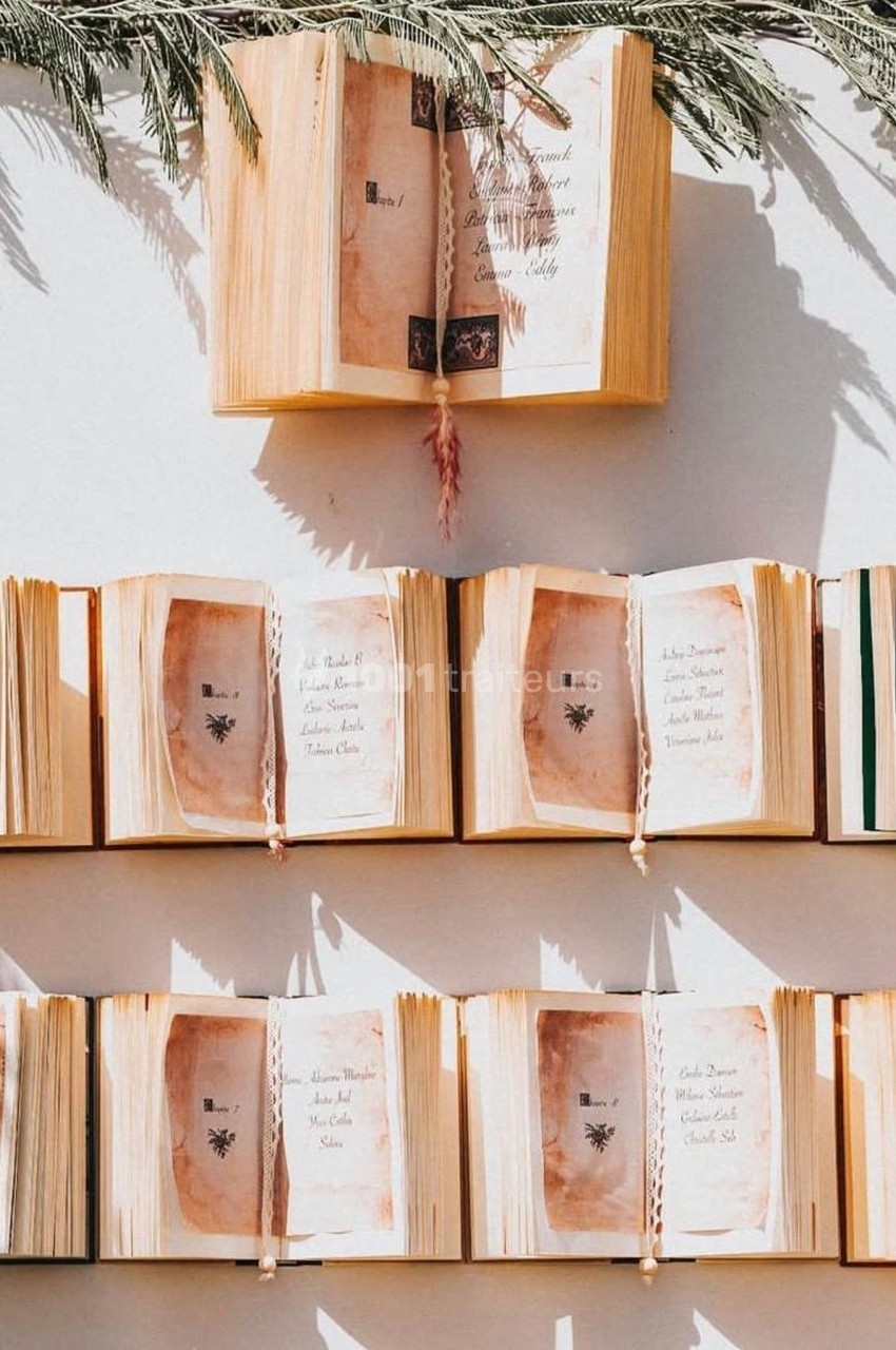 Livres ouverts alignés sur des étagères, pages jaunies exposées à la lumière naturelle avec des ombres de feuillage.