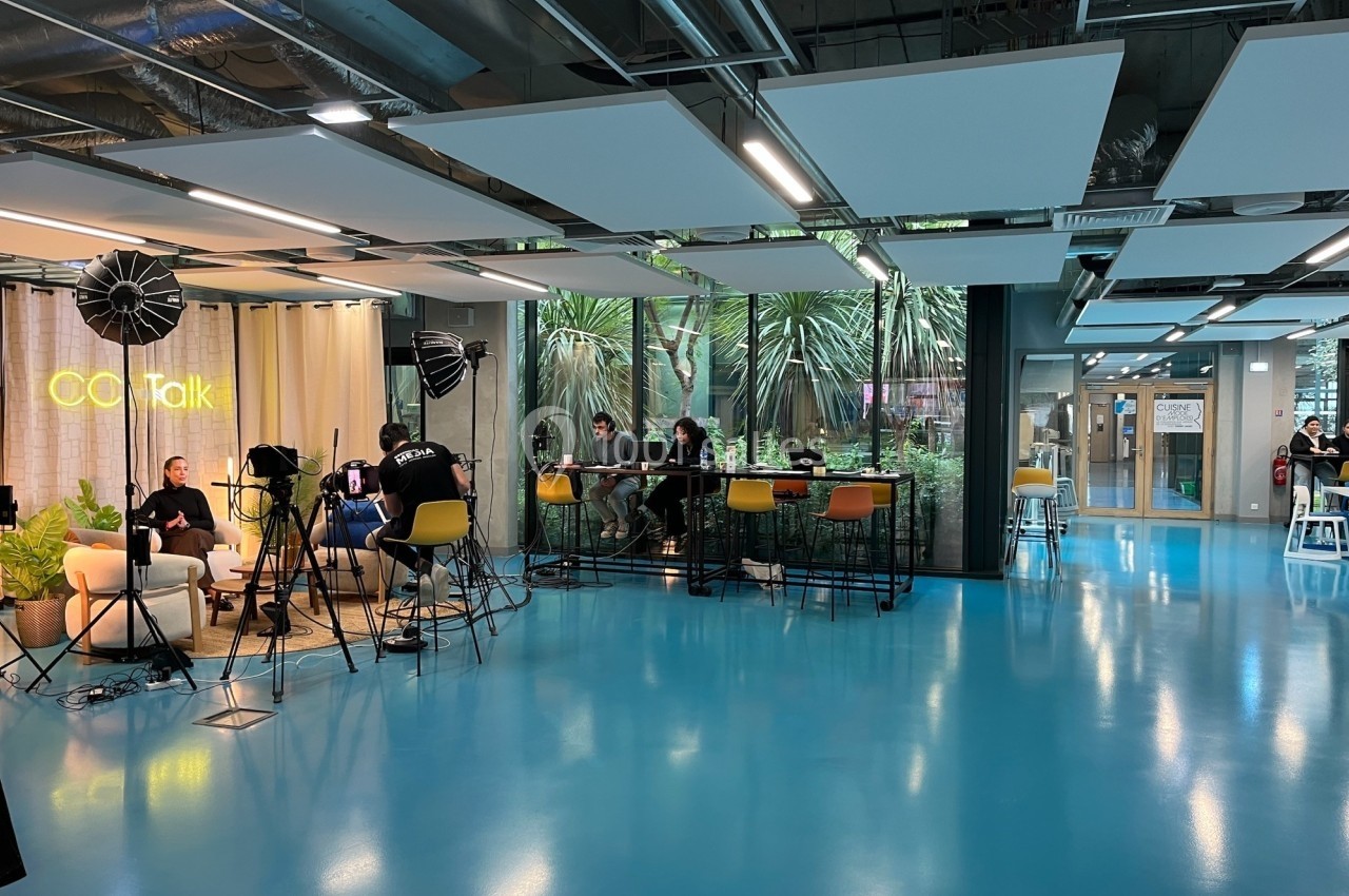 Location salle Nice (Alpes-Maritimes) - Campus Sud des Métiers #3 Espace moderne avec tournage en cours, éclairages et caméras, et personnes travaillant sur des ordinateurs en arrière-plan.
