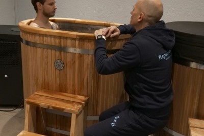 Des personnes assises sur des tapis dans une salle lumineuse, participant à une séance de méditation ou de discussion.