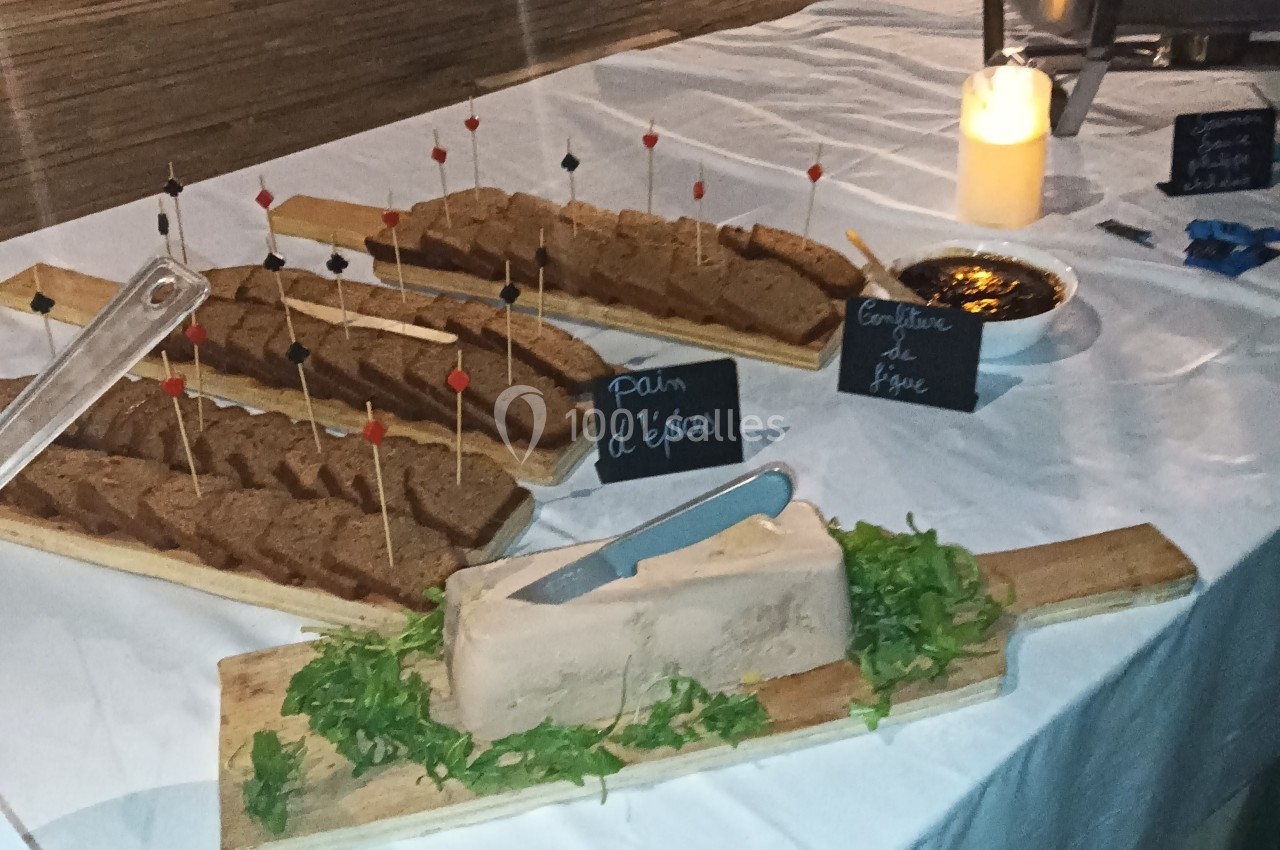 Tranches de pain d'épices sur des plateaux avec une terrine et de la confiture de figue sur une table dressée.
