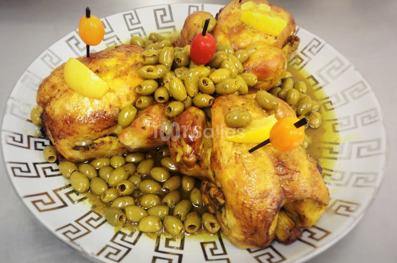 Poulets rôtis garnis d'olives vertes, décorés de tranches de citron et de brochettes colorées sur une assiette.