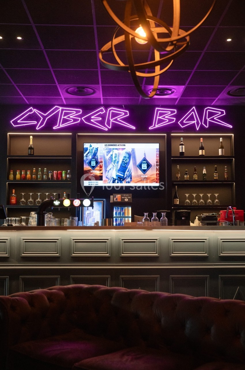 Bar moderne avec néons violets ’Cyber Bar’, comptoir éclairé, étagères de boissons et écrans affichant des publicités.