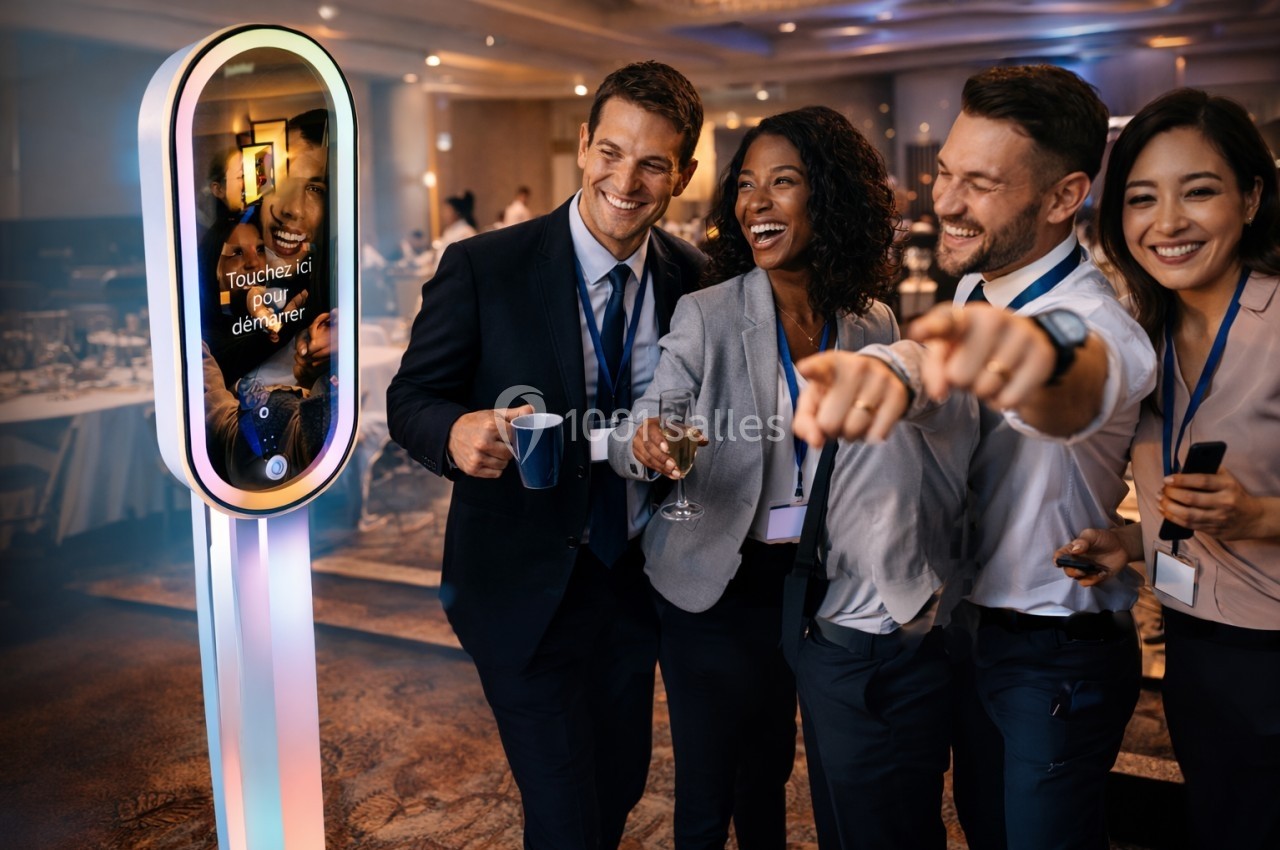 Un groupe de collègues souriants posant devant une borne photo interactive lors d'un événement professionnel.
