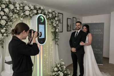 Un groupe de personnes fête un anniversaire dans un salon décoré avec des ballons et une banderole.
