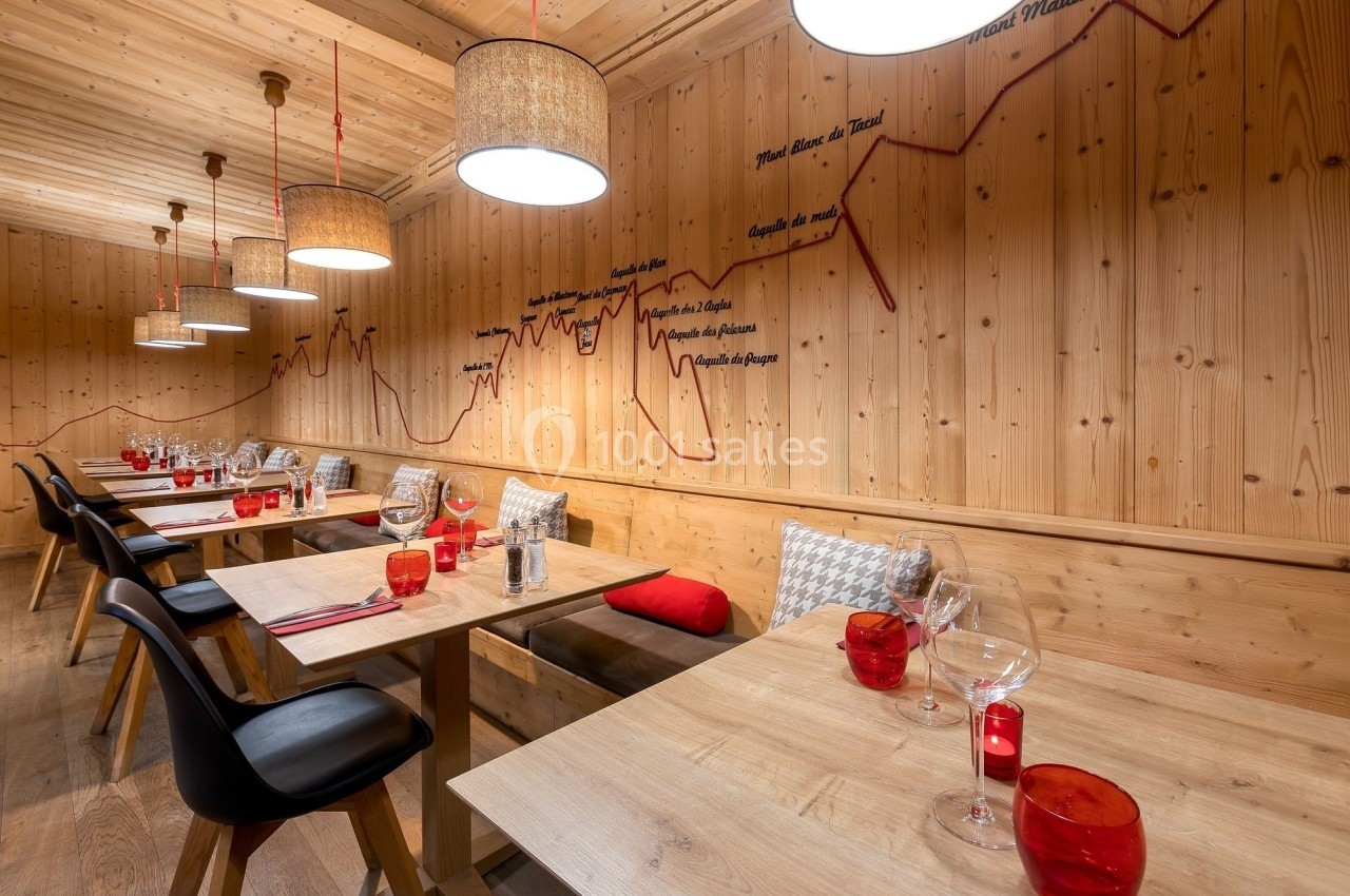 Salle de restaurant en bois avec tables dressées, chaises modernes et décoration murale représentant un graphique.