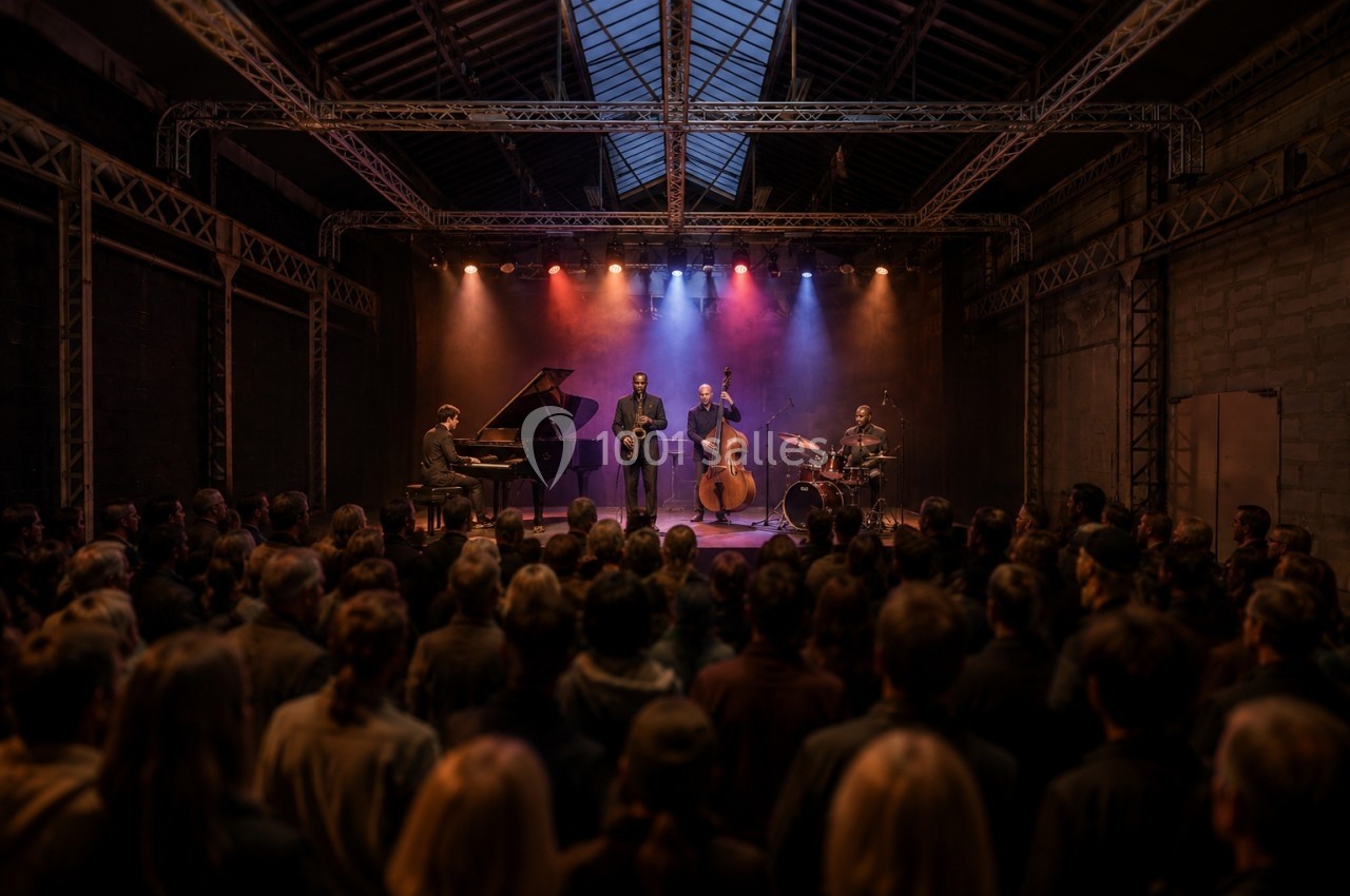Un groupe de musiciens joue sur scène dans une salle sombre, éclairée par des projecteurs colorés, devant un public attentif.