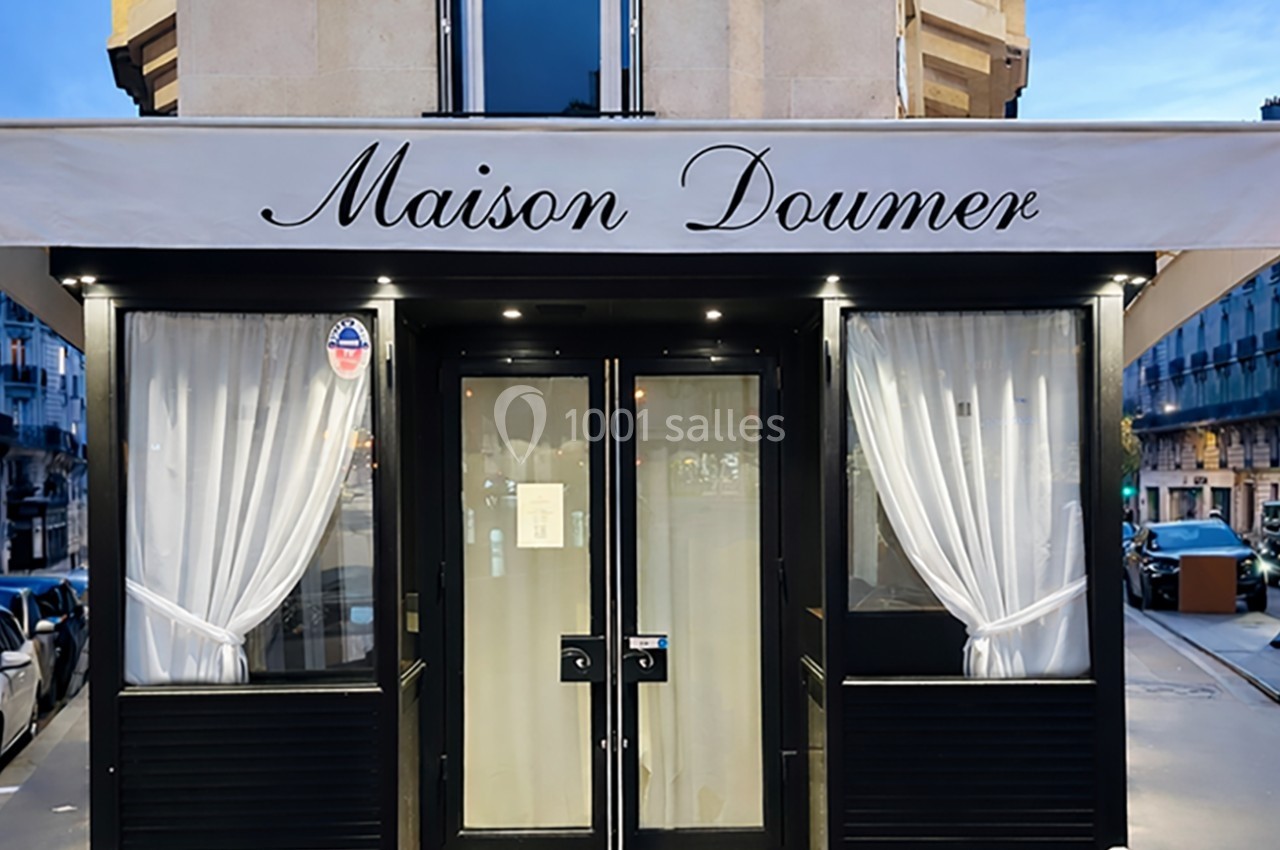 Façade d'un restaurant avec une devanture noire, des rideaux blancs et une enseigne ’Maison Doumer’.