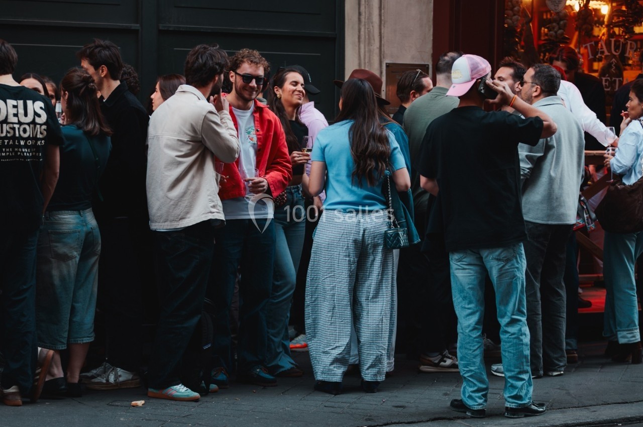 Groupe de personnes discutant et socialisant devant un bâtiment en ville.