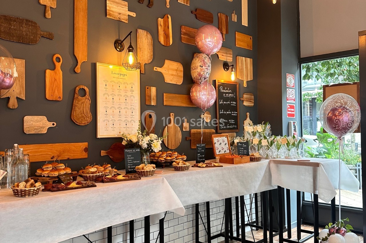 Table garnie de plats variés et décorations festives dans un intérieur chaleureux avec des planches en bois au mur.