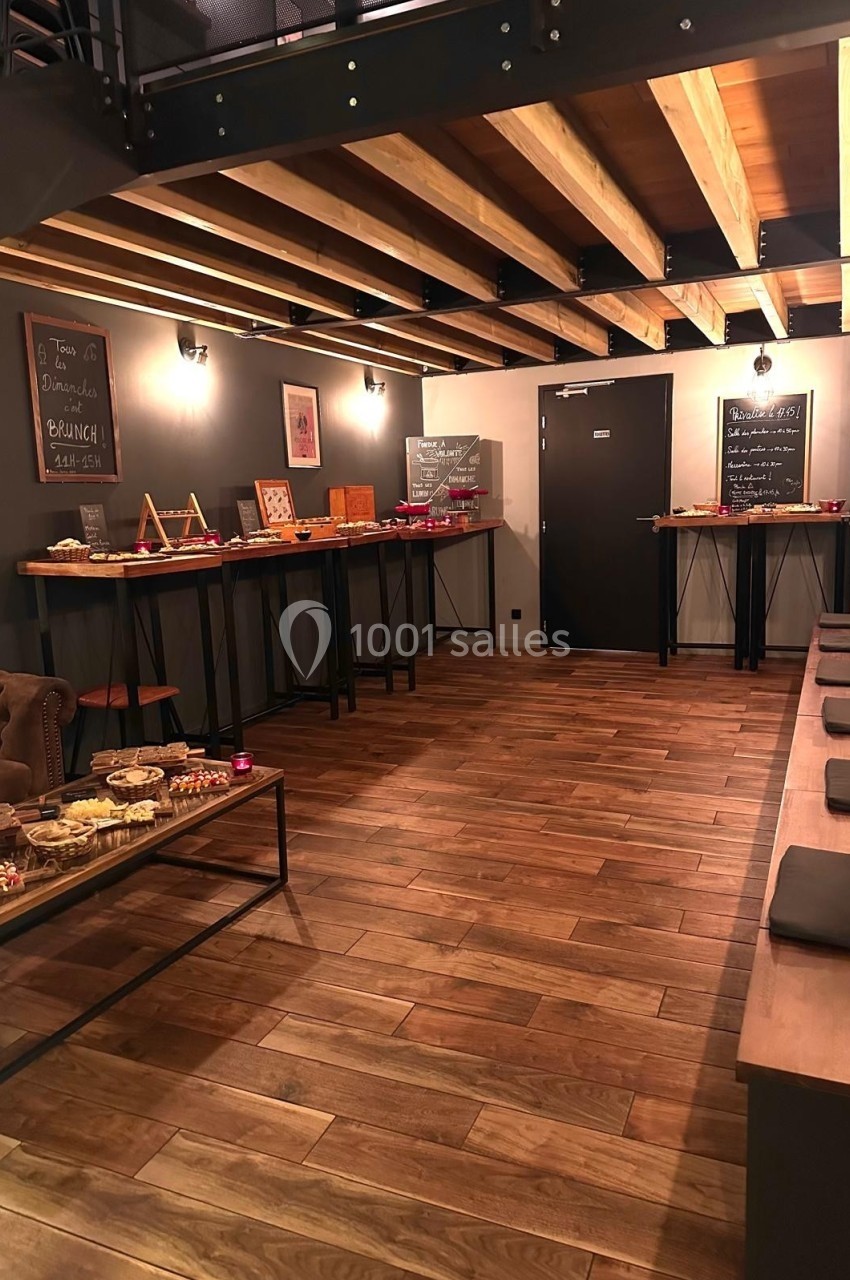 Salle avec parquet en bois, tables garnies de plats et ardoises murales indiquant un brunch.