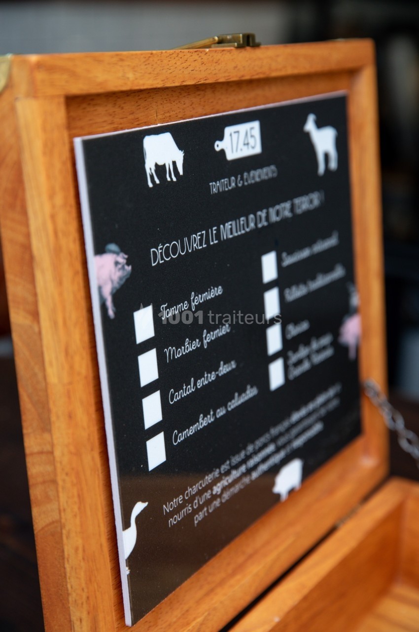 Menu en bois affichant une sélection de fromages fermiers avec illustrations d'animaux et cases à cocher.