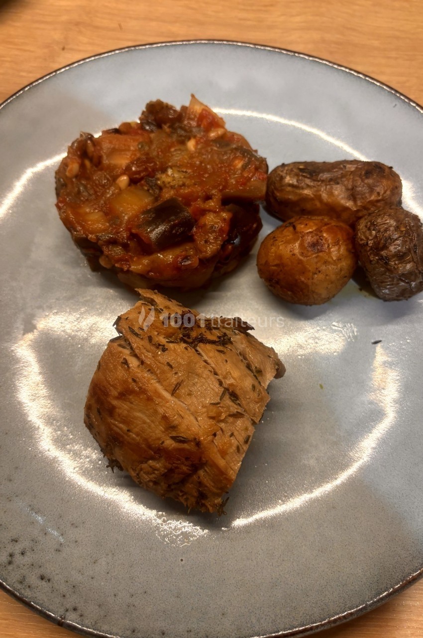 Assiette contenant un pavé de viande, une portion de légumes mijotés et des pommes de terre rôties.