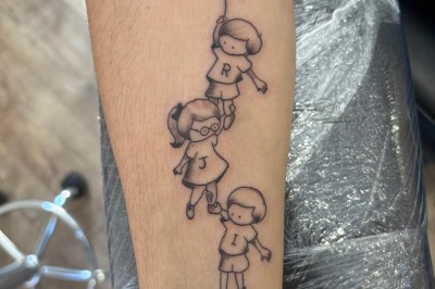 Tatouage floral noir et gris sur une cuisse, représentant des fleurs et des feuilles avec des détails délicats.