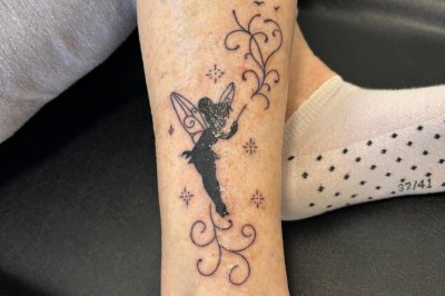 Tatouage sur une jambe représentant un papillon dont une aile se transforme en un bouquet de fleurs détaillées.