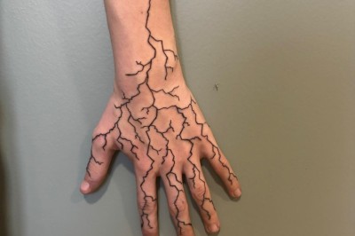 Tatouage sur une jambe représentant un papillon dont une aile se transforme en un bouquet de fleurs détaillées.