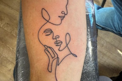 Tatouage sur une jambe représentant un papillon dont une aile se transforme en un bouquet de fleurs détaillées.