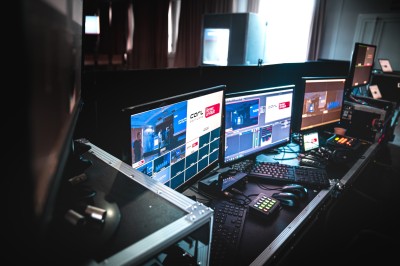 Groupe de personnes souriantes en tenue de soirée utilisant un photobooth numérique dans un cadre festif.