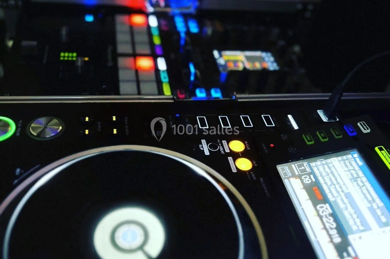 Platines DJ avec boutons lumineux et écran affichant des informations, prêtes pour une performance musicale.