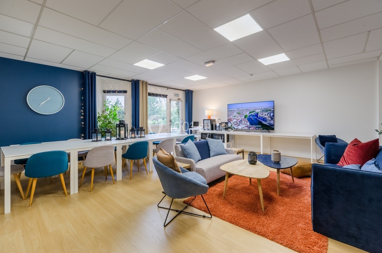 Salle de séjour lumineuse avec coin salon, table à manger, télévision, et décoration moderne sur parquet clair.