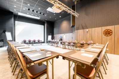 Salle de sport lumineuse avec vélos d'exercice, tapis de course et miroir mural, sol en bois.