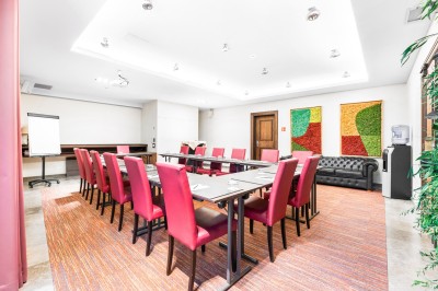 Salle de sport lumineuse avec vélos d'exercice, tapis de course et miroir mural, sol en bois.