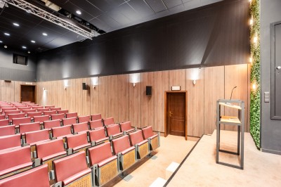 Salle de sport lumineuse avec vélos d'exercice, tapis de course et miroir mural, sol en bois.
