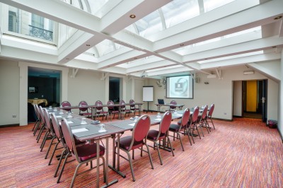 Salle de sport lumineuse avec vélos d'exercice, tapis de course et miroir mural, sol en bois.