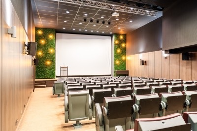 Salle de sport lumineuse avec vélos d'exercice, tapis de course et miroir mural, sol en bois.