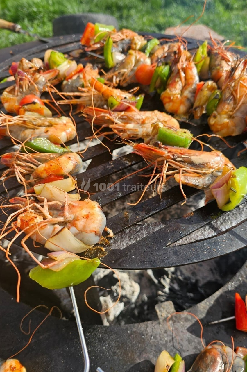 Crevettes et légumes colorés grillés sur une brochette, cuisant sur un barbecue en plein air.
