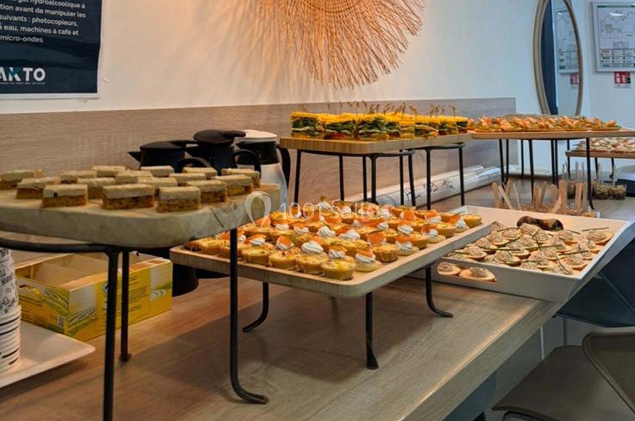 Plateau de canapés variés disposés sur une table dans un espace intérieur lumineux.