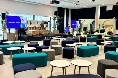 Miniature Exemple de disposition alternative de la salle Salle de conférence moderne avec poufs colorés, tables basses et écrans affichant une présentation.