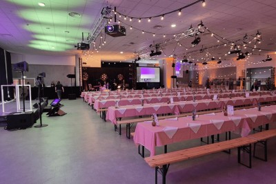 Miniature Forum 300 en configuration dîner Salle de conférence moderne avec poufs colorés, tables basses et écrans affichant une présentation.