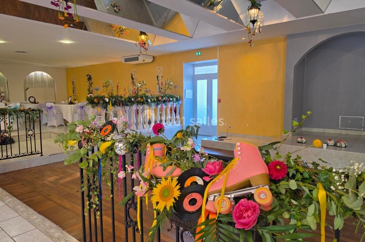 Décoration colorée avec fleurs, patins à roulettes et disques vinyles sur une rambarde dans une salle lumineuse.