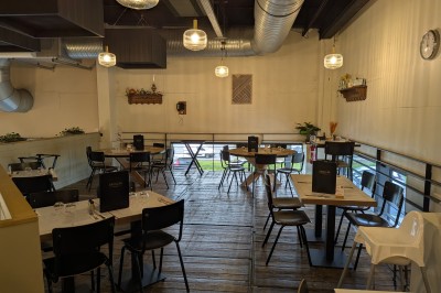 Poulet rôti garni de tranches d'oignon servi dans une assiette, une main utilise une fourchette pour le déguster.