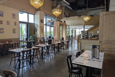 Miniature Rez de Chaussée Poulet rôti garni d'oignons caramélisés sur une assiette, avec une main utilisant une fourchette en arrière-plan.