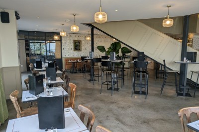 Miniature Rez de Chaussée Poulet rôti garni d'oignons caramélisés sur une assiette, avec une main utilisant une fourchette en arrière-plan.