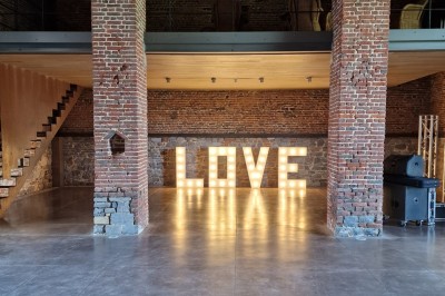 Miniature Location salle Assesse (Province de Namur) - Château Vivier l’Agneau et La Grange #4 Bar en pierre avec comptoir sombre, quatre tabourets noirs et un sol en carreaux gris foncé dans une ambiance rustique.