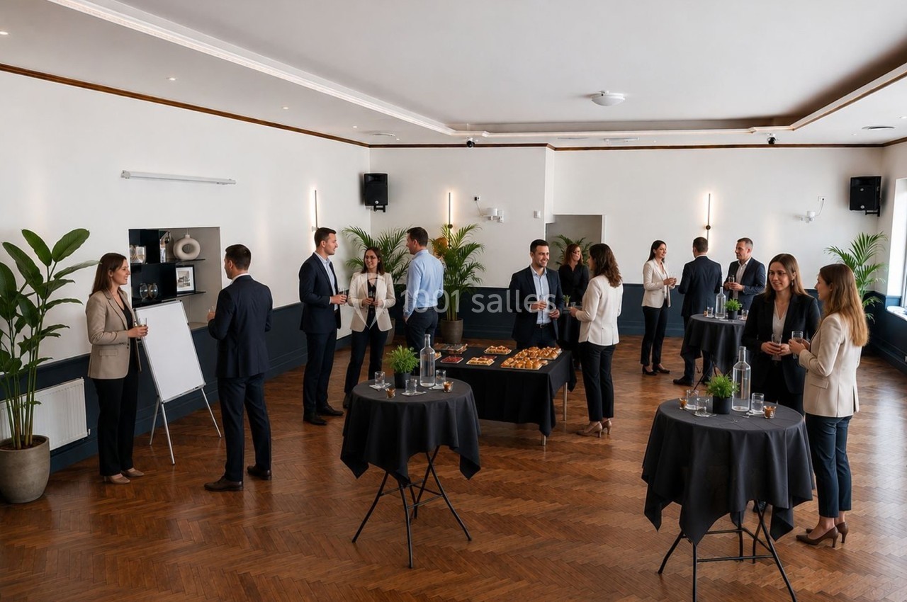 Personnes en tenue professionnelle discutant autour de tables dans une salle de réception avec buffet et plantes décoratives.