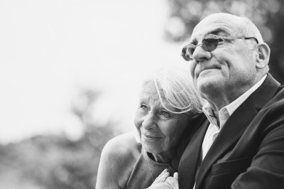 Un couple danse sous des lumières colorées et une ambiance de fumée lors d'une réception festive.