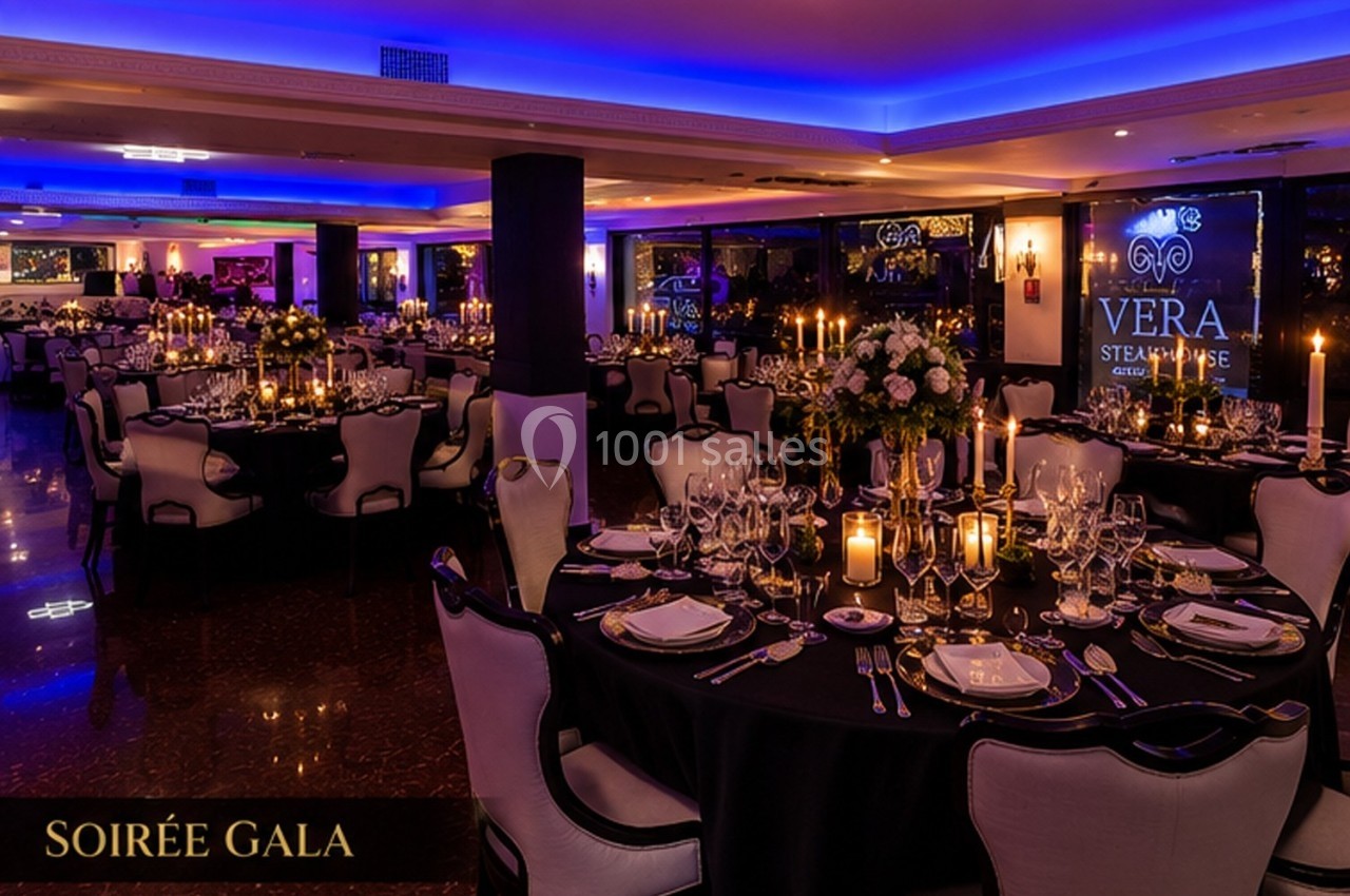 Salle de réception élégamment décorée pour une soirée de gala, avec tables dressées et éclairage tamisé.