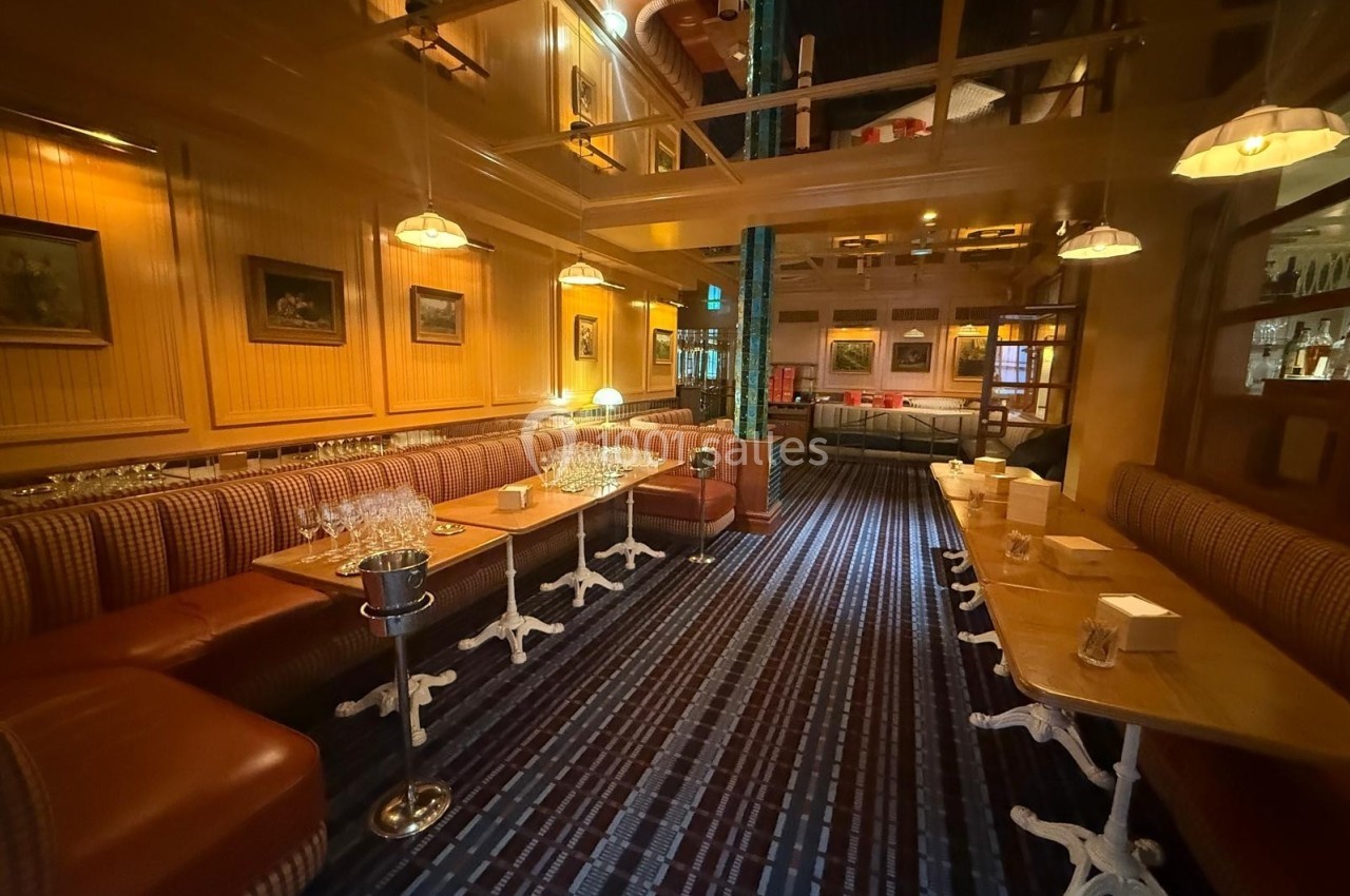 Salle de restaurant chaleureuse avec banquettes en cuir, tables dressées et éclairage tamisé.