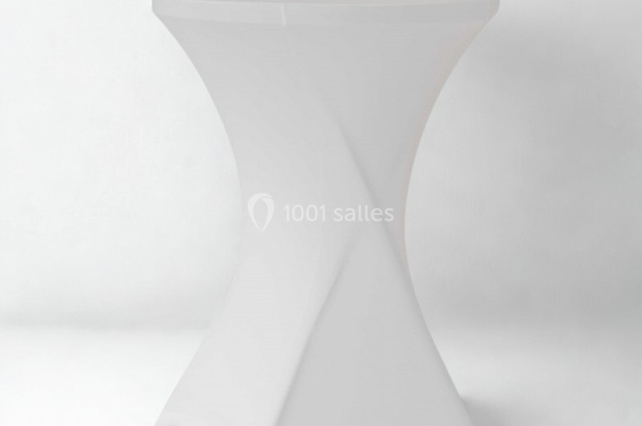 Table haute blanche avec housse ajustée, posée sur un fond uni clair.