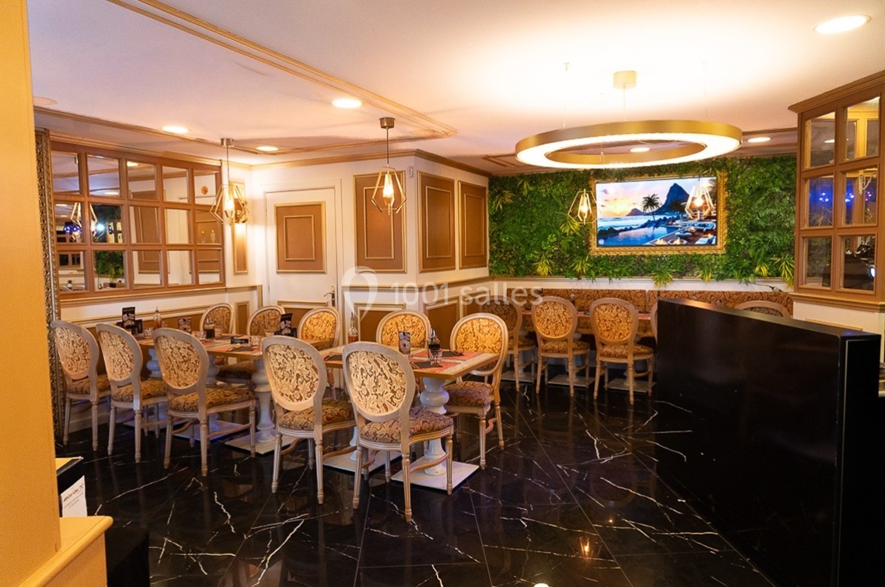 Salle de restaurant élégante avec tables en bois sculpté, chaises assorties et mur végétal décoratif.