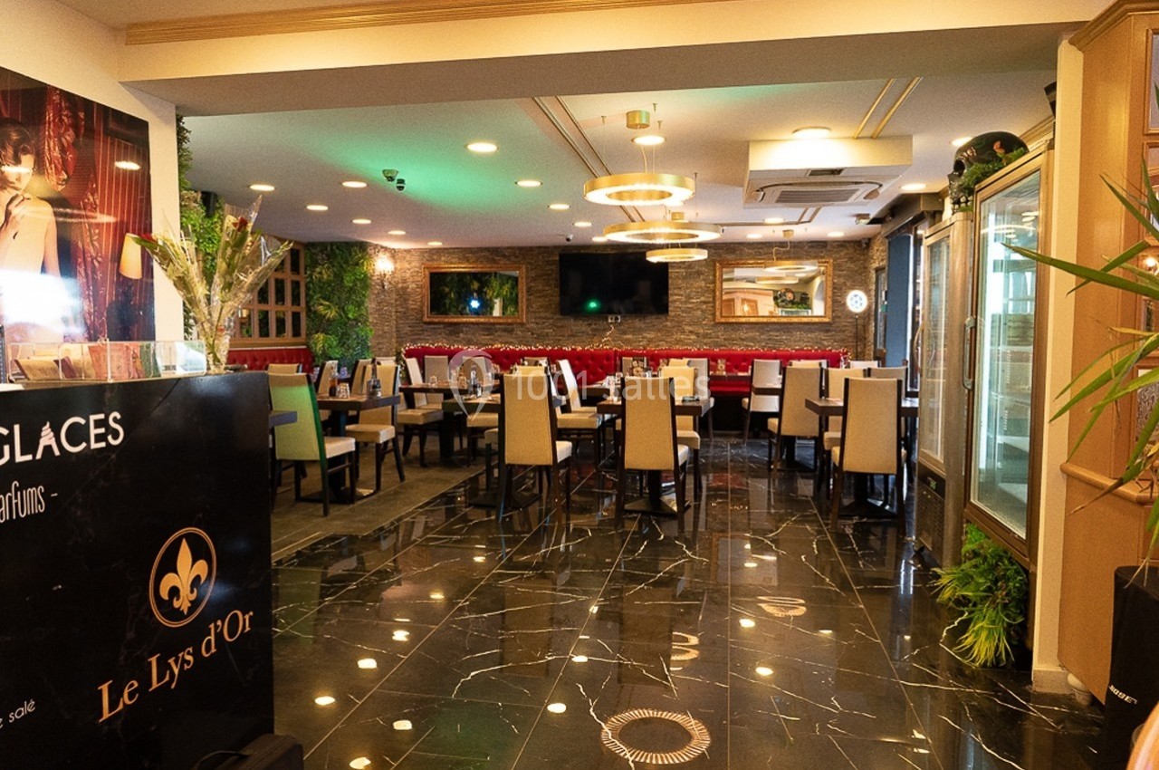 Salle de restaurant élégante avec tables dressées, chaises rembourrées, décoration moderne et éclairage chaleureux.