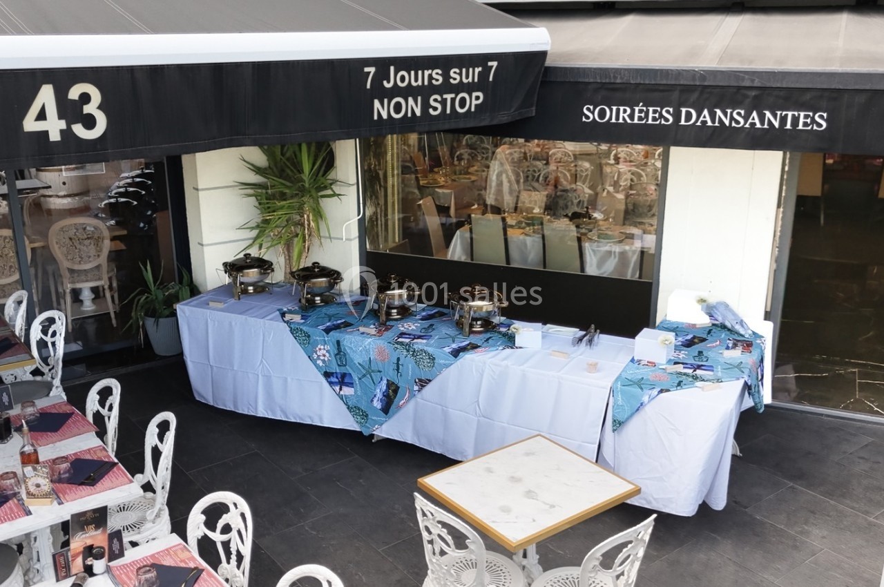 Terrasse d’un restaurant avec tables dressées et buffet installé sous un auvent, mentionnant ’Soirées dansantes’.