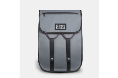 Sac à dos gris avec rabat, logo ’Back Market’ visible, deux sangles noires et une poche zippée sur le dessus.