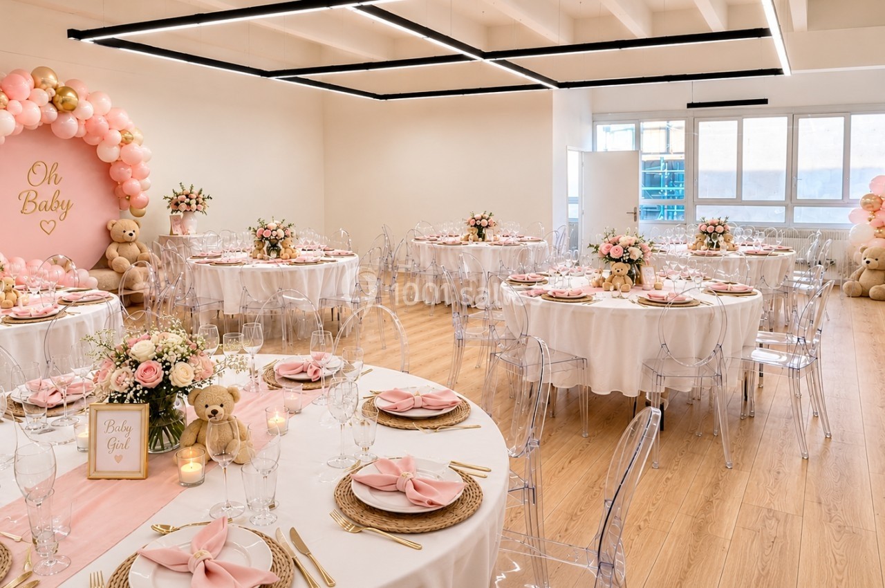 Salle décorée pour une baby shower avec tables dressées, ballons roses et dorés, et peluches en décoration.